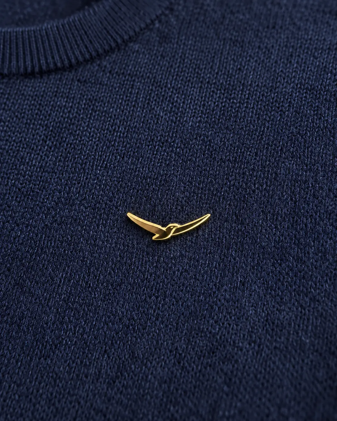 The gold condor pin on deep navy cashmere